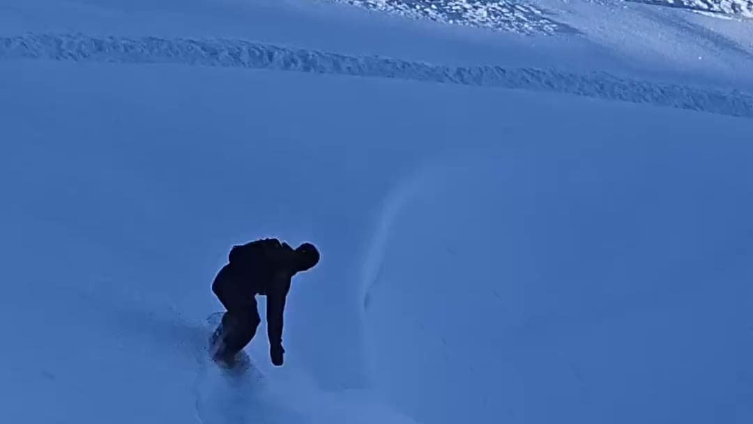 Rider trazando una curva en nieve virgen fuera de pista