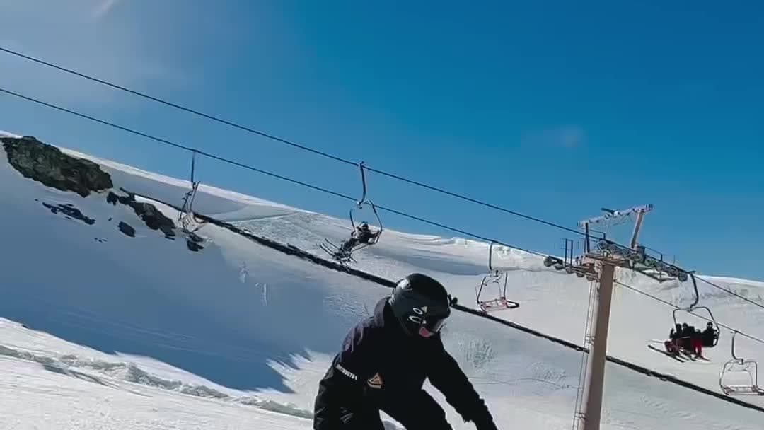 Monitor de Snow Riders Academy haciendo un truco de snowboard sobre un módulo