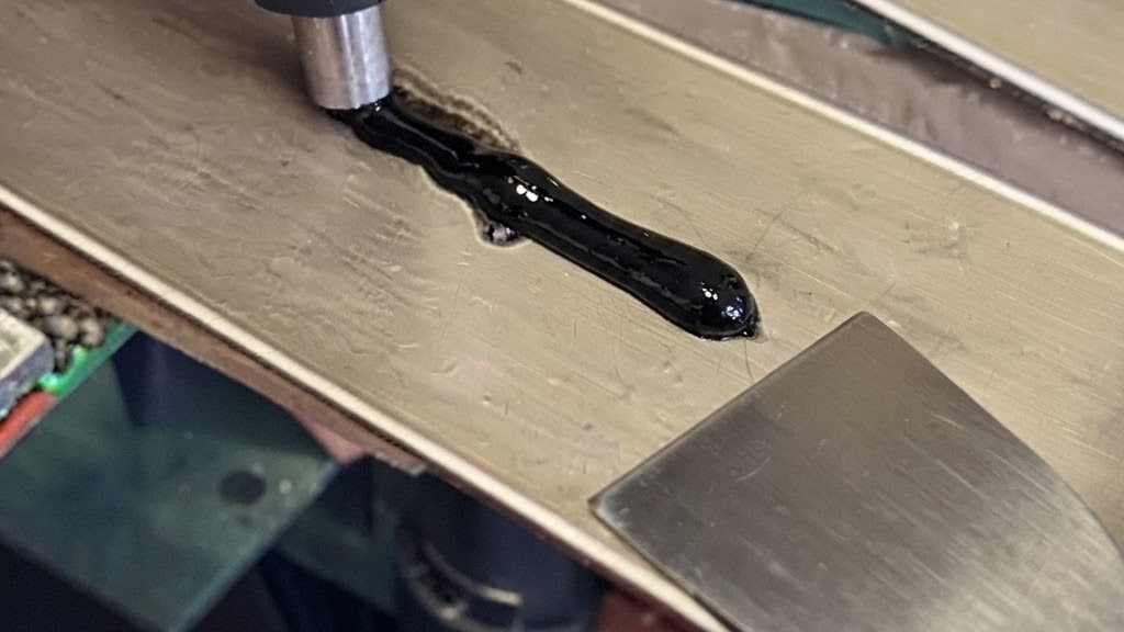 Reparación de un corte en la base: el material se aplica fundido con la herramienta y se nivela después con la rasqueta metálica